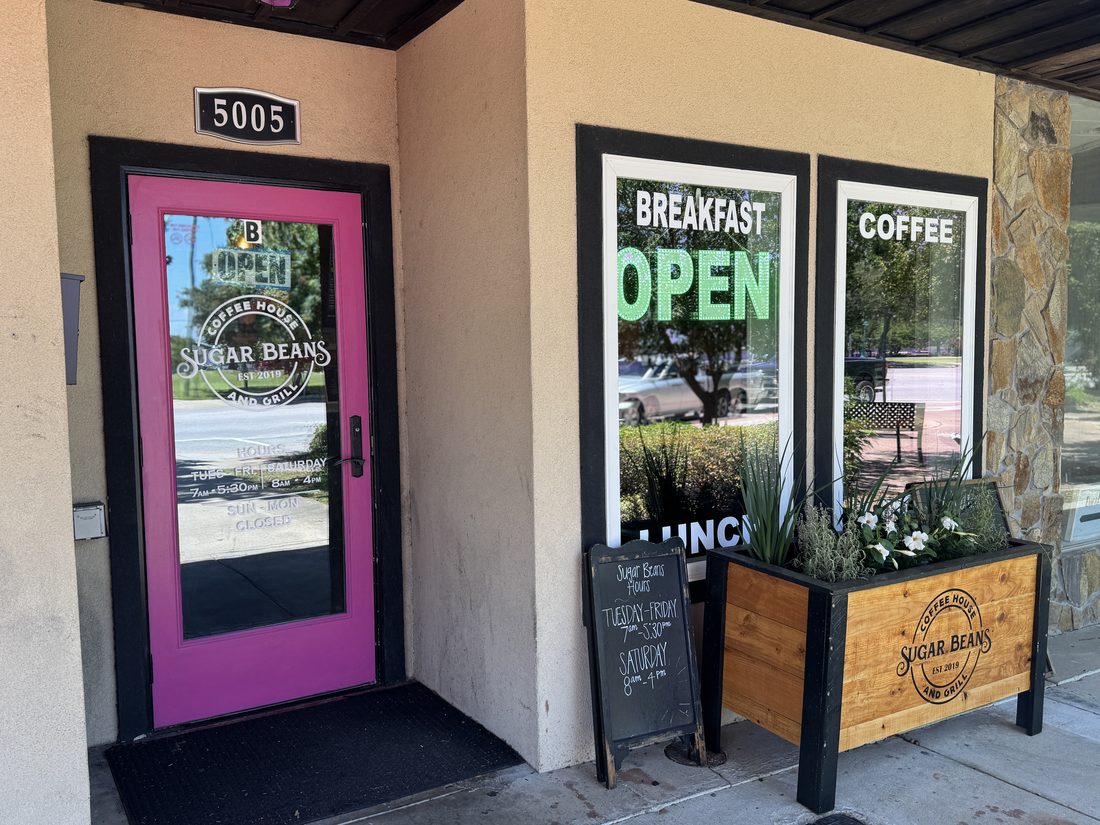 The Sugar Beans coffee house and grill storefront with its pink door on Main Street.