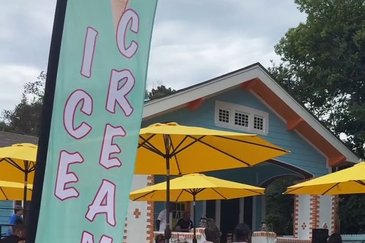 Tootsie's by the River ice cream parlor with yellow umbrellas and patio seating.
