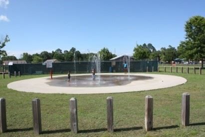 Children playing at a park splash pad in Moss Point.