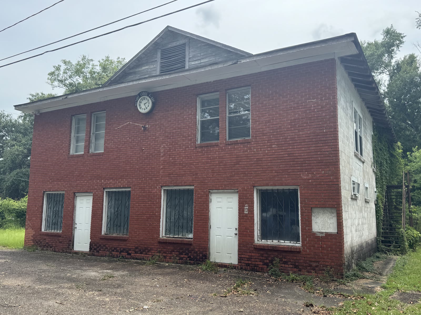 A two story red brick building with a clock reading Victory Lodge and a Prince Hall Masonic cornerstone, on Bowen Street in Moss Point, photographed in 2026.