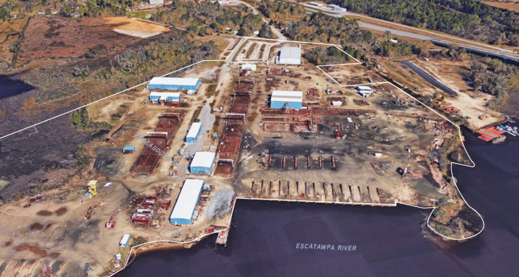 An aerial view of the Halter shipyard on Elder Ferry Road along the Escatawpa River, its buildings and ways lining the bank.