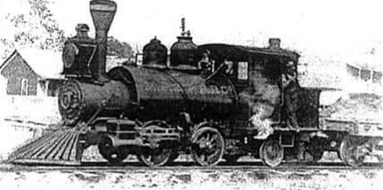 A small early steam locomotive of the Moss Point and Pascagoula Railroad, lettered engine No. 2, standing on the tracks with a depot building behind it in the 1890s.