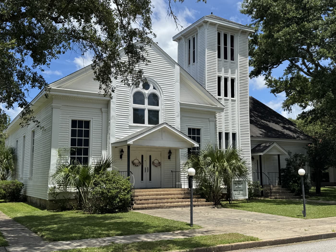 The white clapboard Presbyterian church on Dantzler Street in Moss Point, with a tall square bell tower and an arched Gothic window.