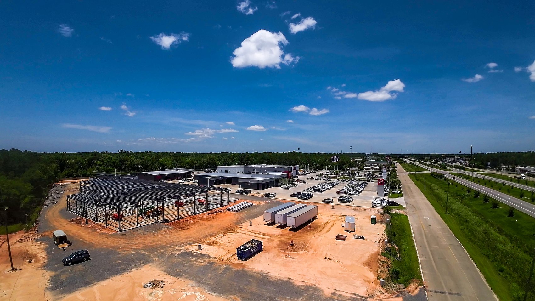 Aerial drone view of the Cannon Ford dealership under construction on the Hwy 63 corridor, with the rest of the Cannon dealership row beyond