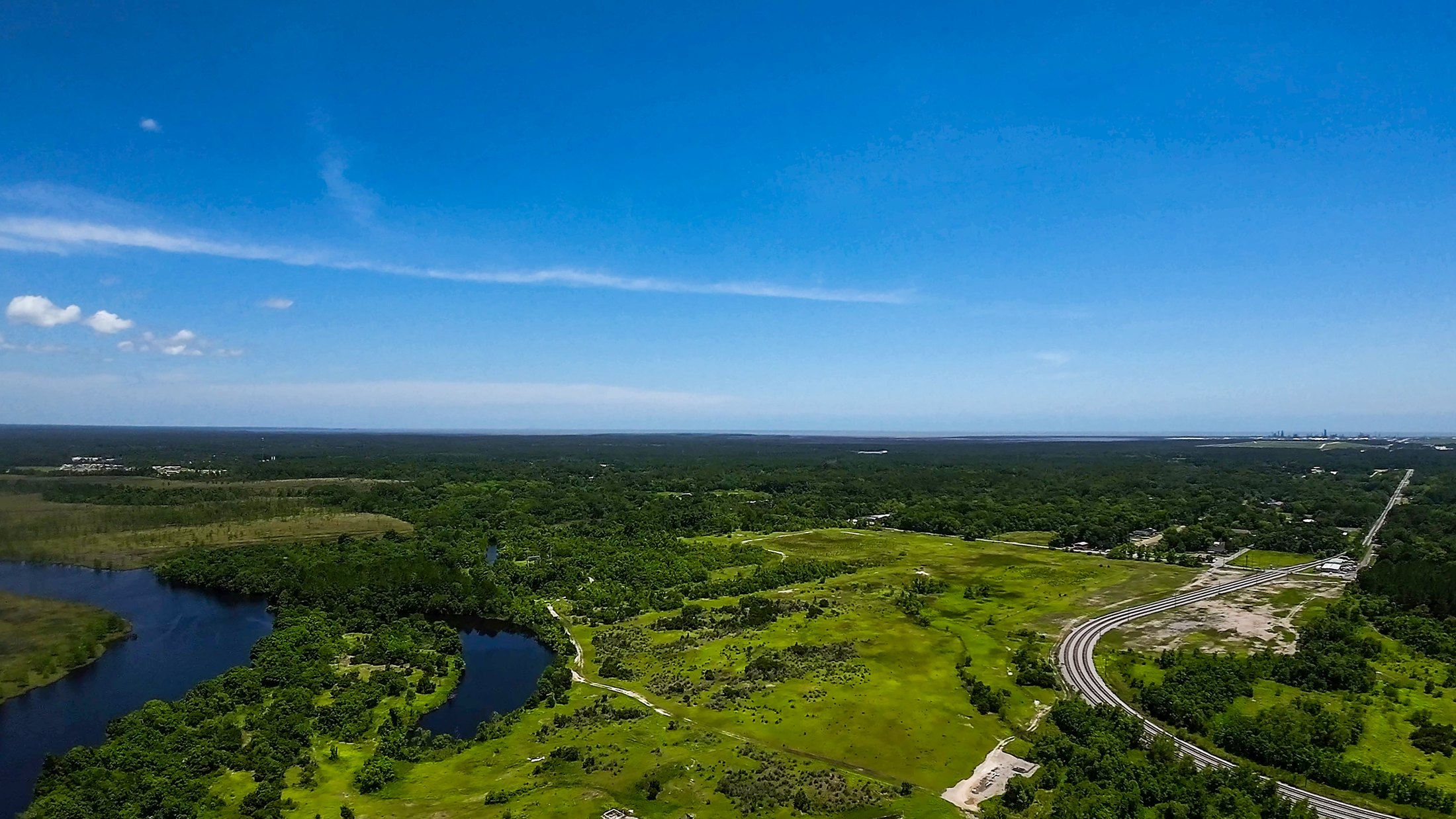 Aerial drone view of the Old Papermill site in Moss Point, with the river and the cleared mill footprint