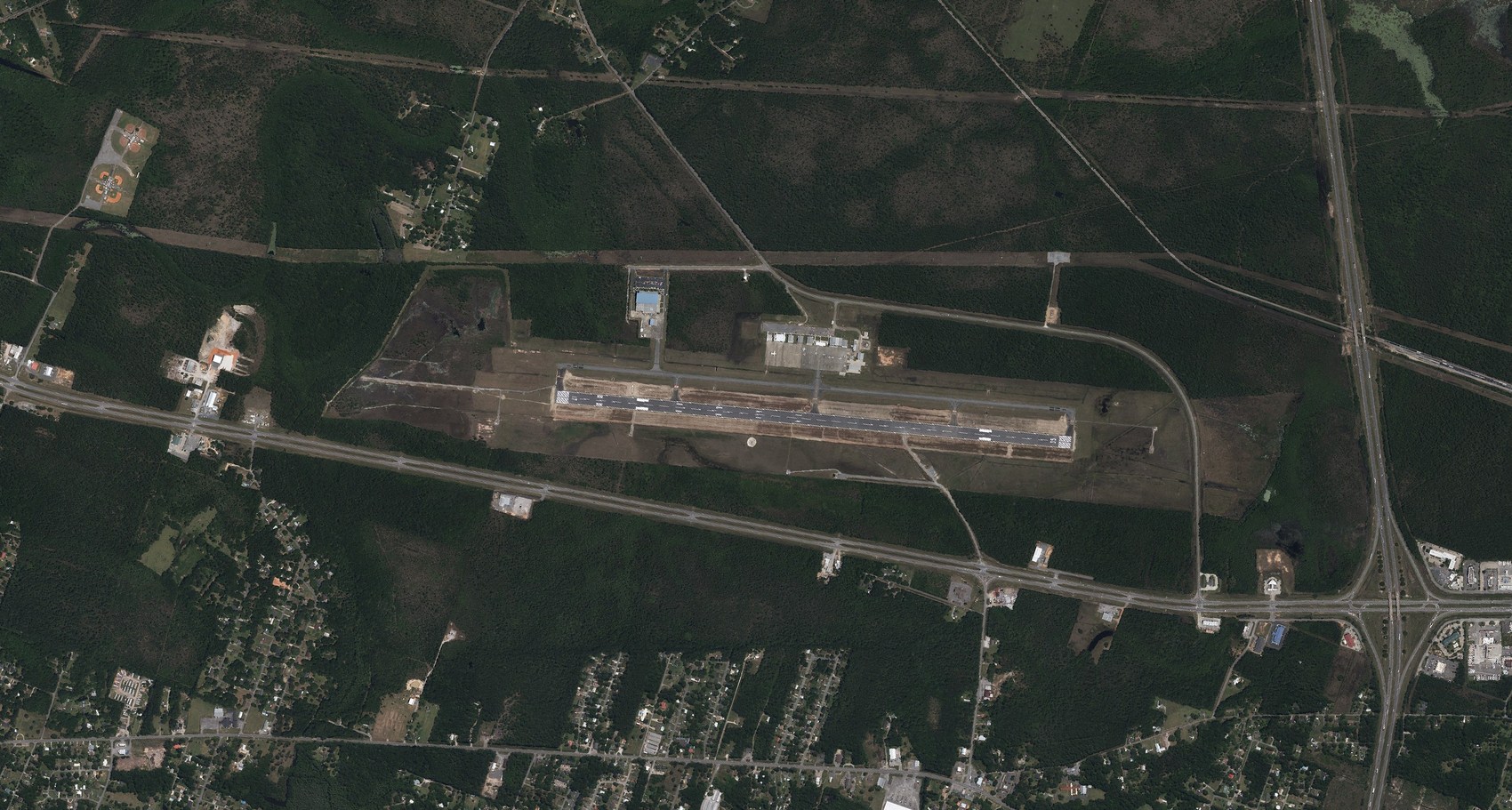 Aerial view of Trent Lott International Airport showing the runway, taxiways, and terminal apron