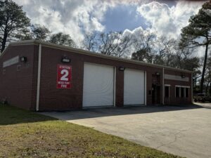 Dr. Reuben P. Morris Fire Station, Moss Point Station 2, brick building on Martin Luther King Boulevard with the bold red 'STATION 2 MOSS POINT FIRE' sign on the front wall and apparatus bay doors closed.
