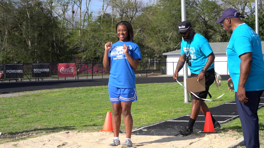 An athlete smiles with excitement after completing the standing long jump at the Special Olympics Area 12 Track and Field Games at Jerry Alexander Stadium