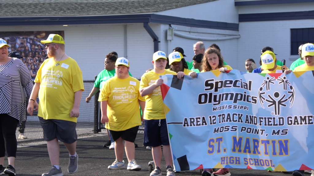 St. Martin High School athletes in yellow carry their Special Olympics Mississippi Area 12 Track and Field Games banner during the processional at Jerry Alexander Stadium