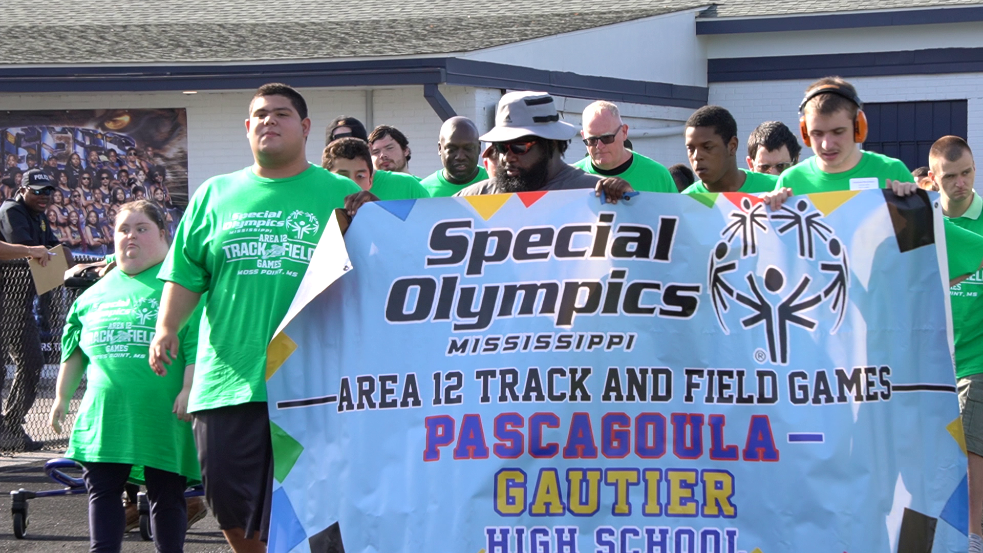 Team Pascagoula-Gautier High School athletes in green carry their Special Olympics Mississippi Area 12 Track and Field Games banner during the processional at Jerry Alexander Stadium