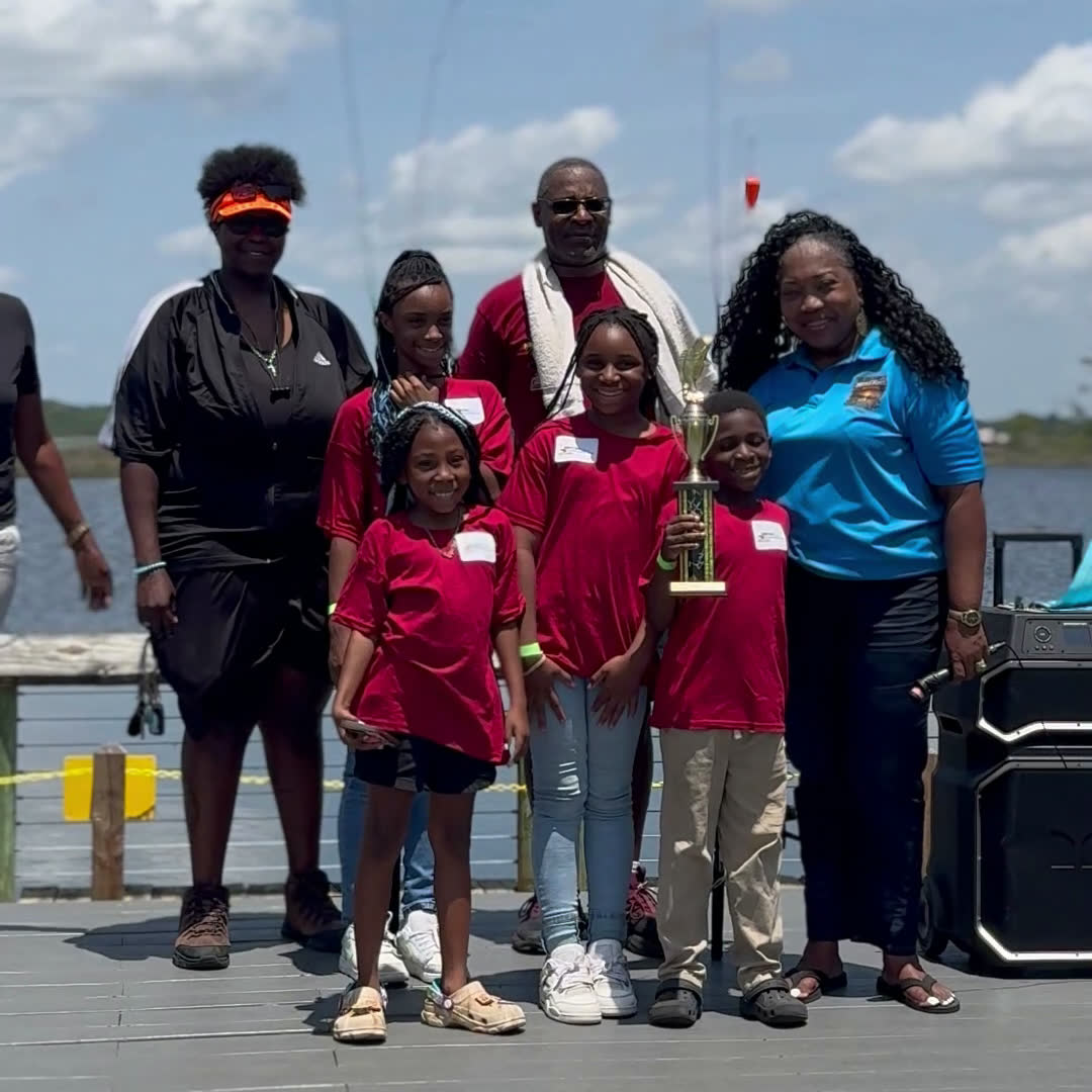 The youth team from Amazing Grace Missionary Baptist Church stands on the dock with their first place team trophy at the Faith Fest Fishing Rodeo