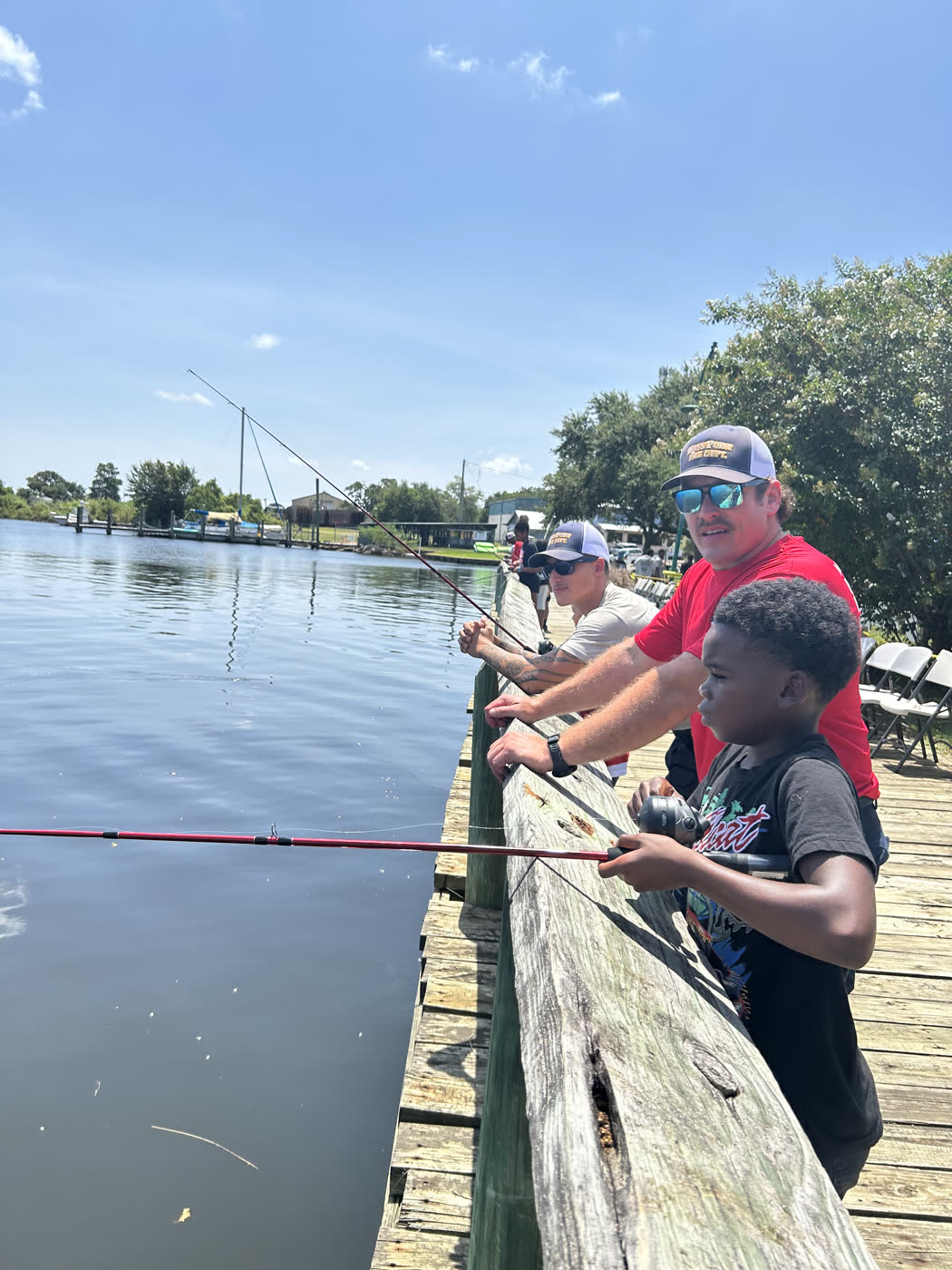 Families fish shoulder to shoulder from the boardwalk at the Faith Fest Fishing Rodeo on the Moss Point Downtown Riverfront