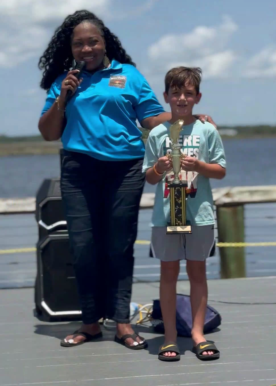 Phoenix holds his first place trophy on the dock as winners are announced at the Faith Fest Fishing Rodeo in Moss Point