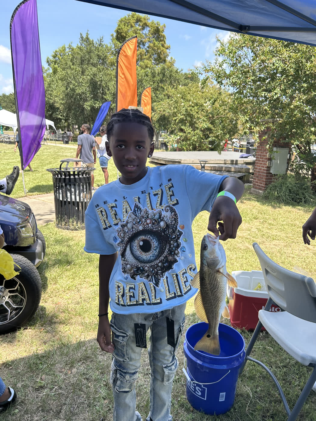 A young angler proudly holds up a redfish he caught at the Faith Fest Fishing Rodeo in Moss Point