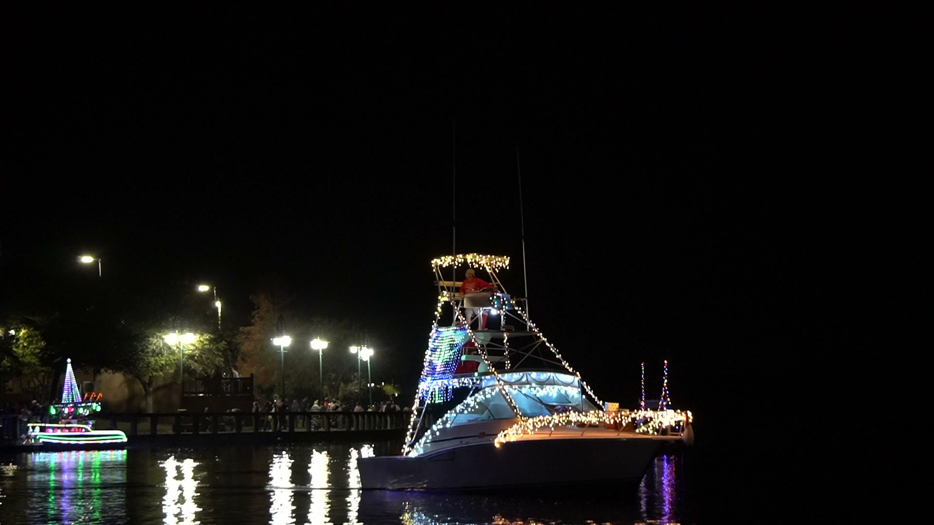 A boat strung with Christmas lights passes the downtown riverfront during last year's Christmas by the River boat parade