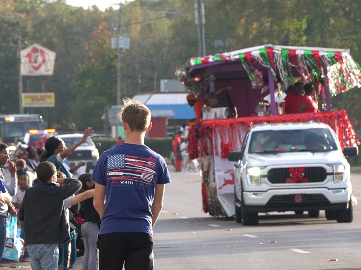 A decorated Christmas float pulled by a white pickup rolls down Main Street during last year's Christmas by the River Land Parade as children watch from the curb